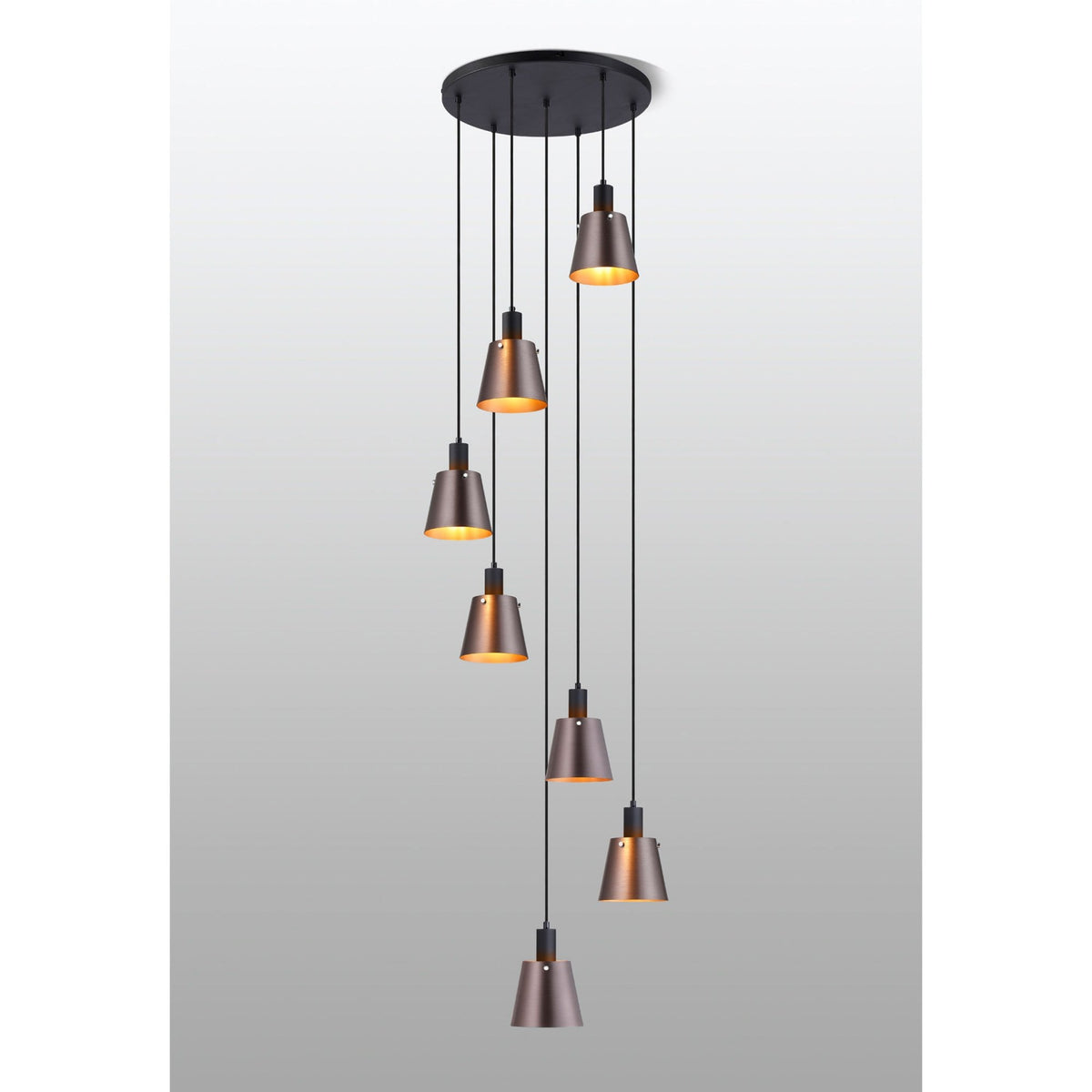 Seven antique copper and black pendant lights hanging from a circular black ceiling rose.