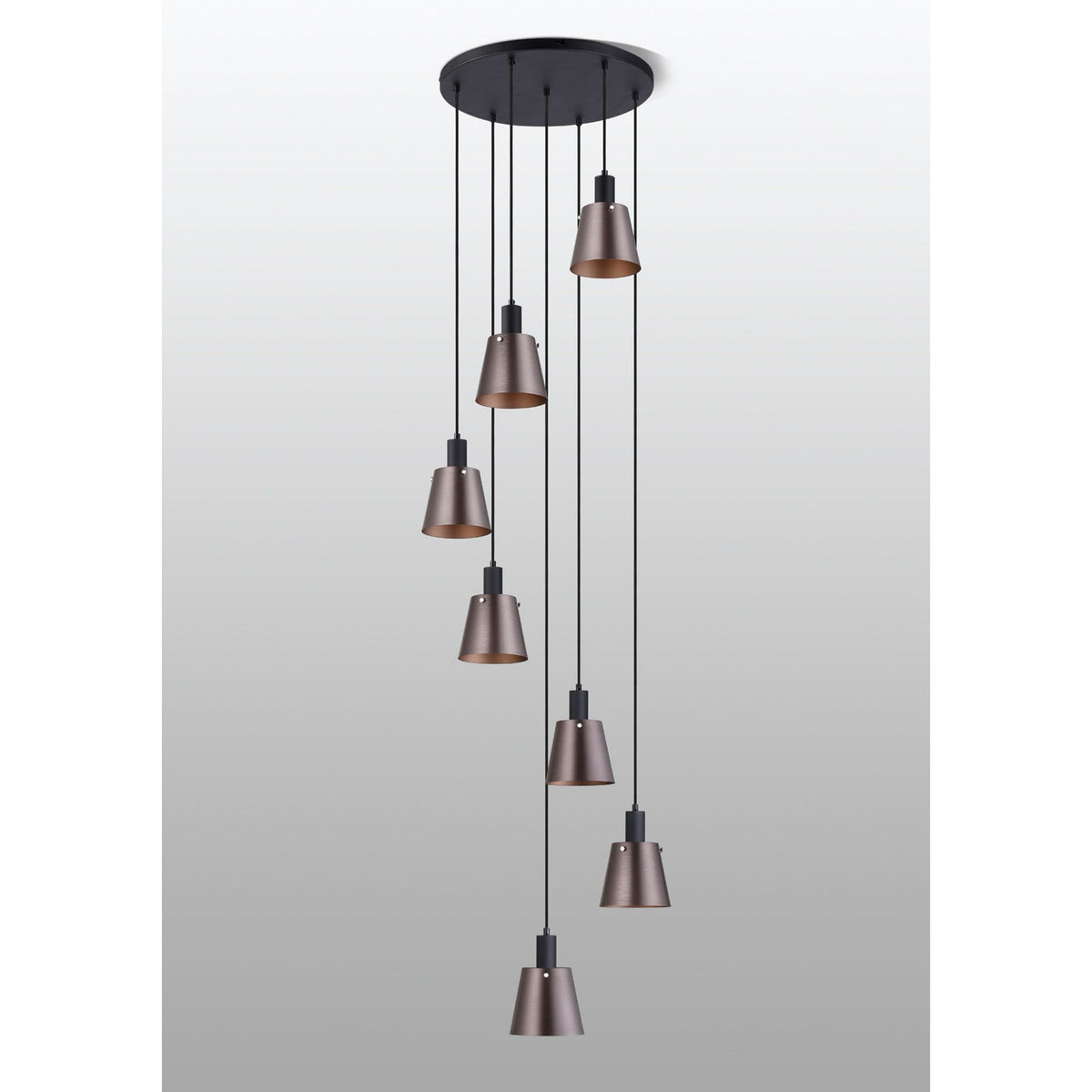 Seven antique copper and black pendant lights hanging from a circular black ceiling rose.