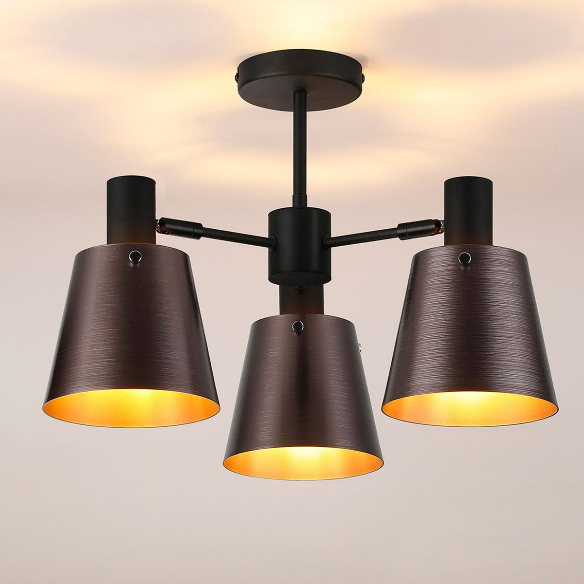 A three-arm ceiling light in an aged bronze finish with industrial-style conical shades.
