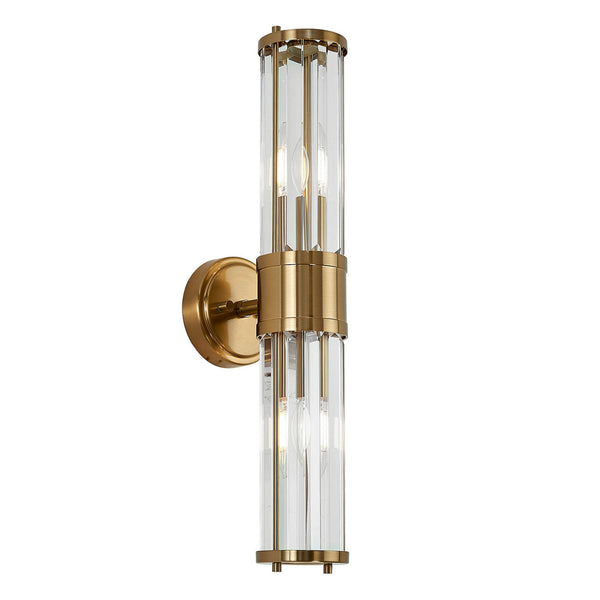 A modern brass and fluted glass wall light against a white background.