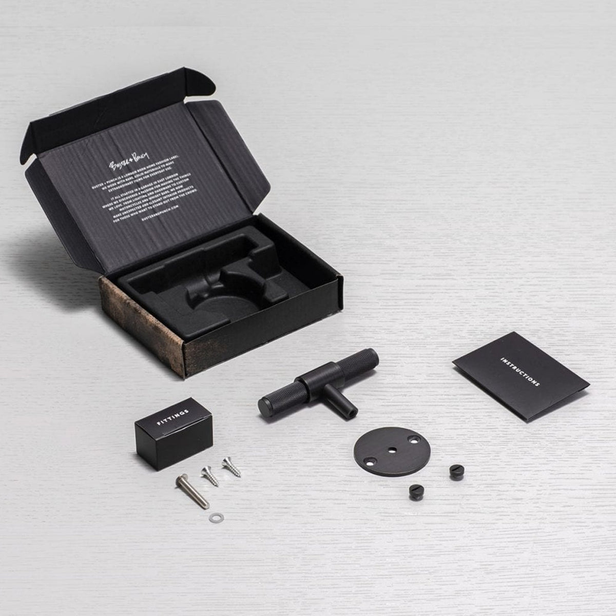 Buster + Punch door handle kit with packaging, instructions, fittings box, screws, and handle components