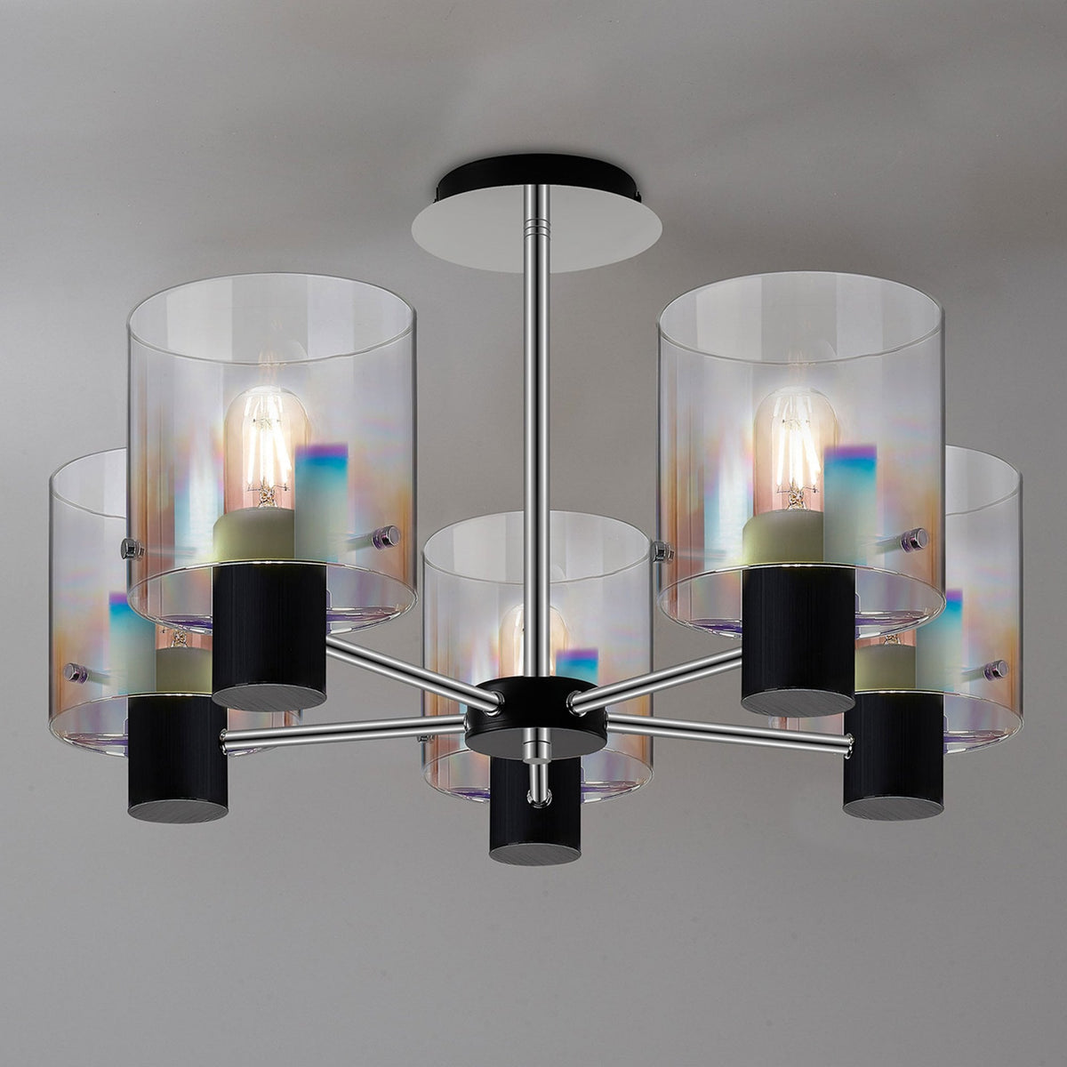 A modern five-light chandelier with clear and iridescent glass shades on a grey background.