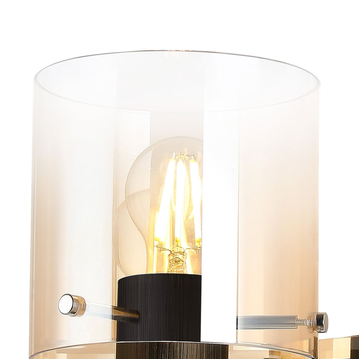 Close-up of the wall light's cylindrical amber and clear glass shade with an illuminated bulb.