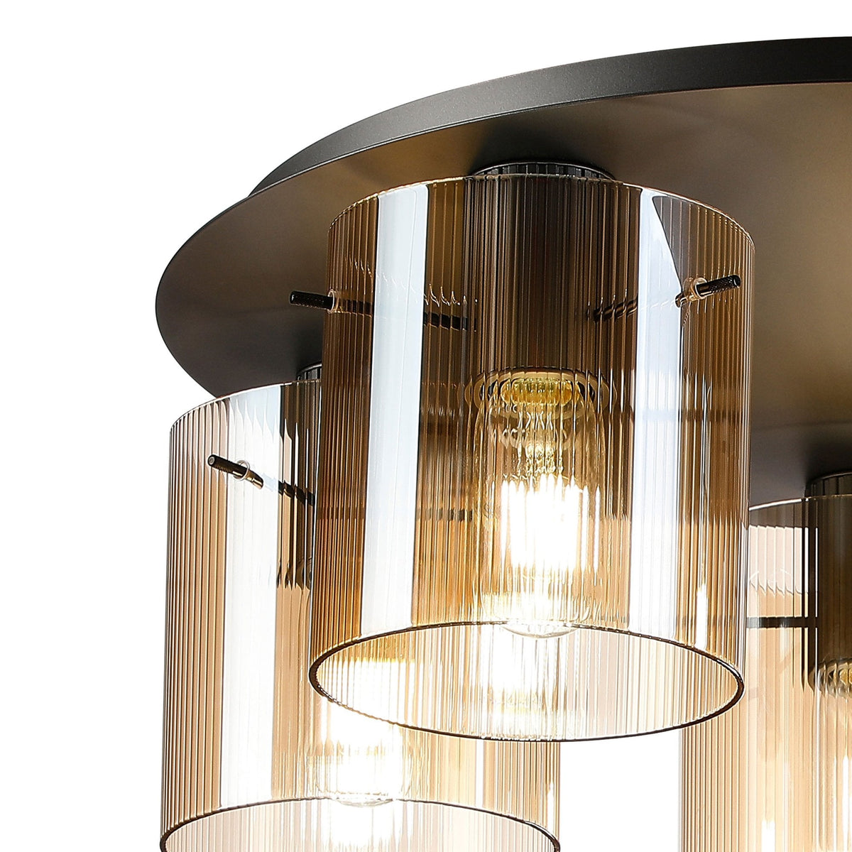A close-up of a modern five-light ceiling fitting with amber fluted glass shades.