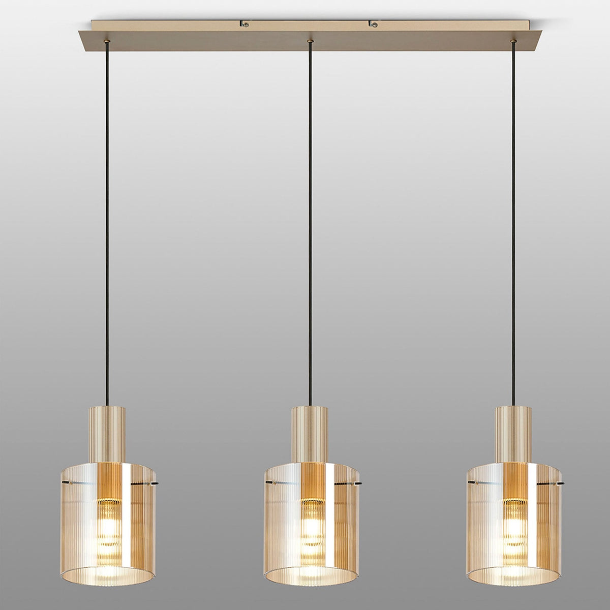 Three pendant lights with amber glass shades and gold-coloured fixtures on a rectangular bar.