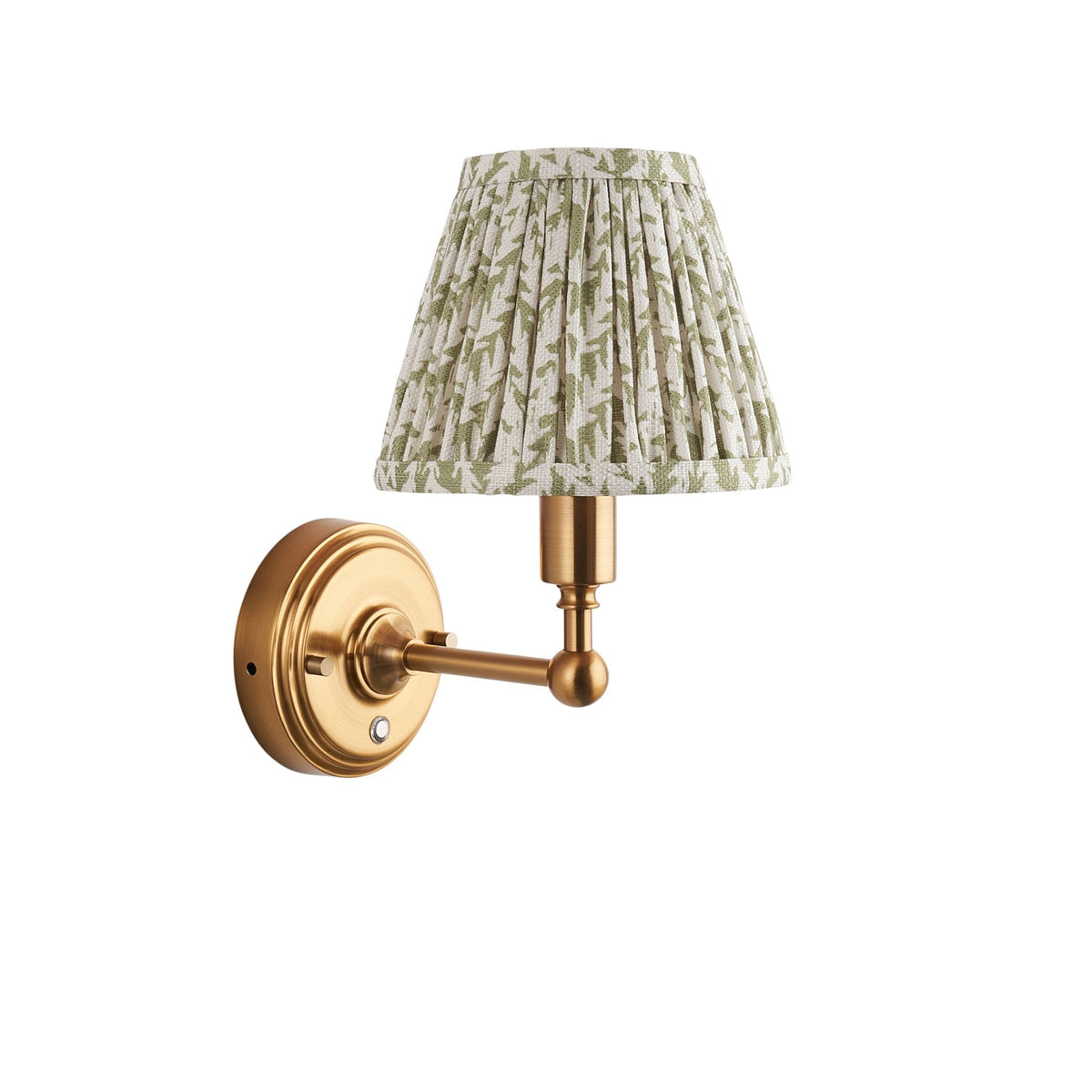 A brass wall sconce with a pleated green and white botanical print lampshade.