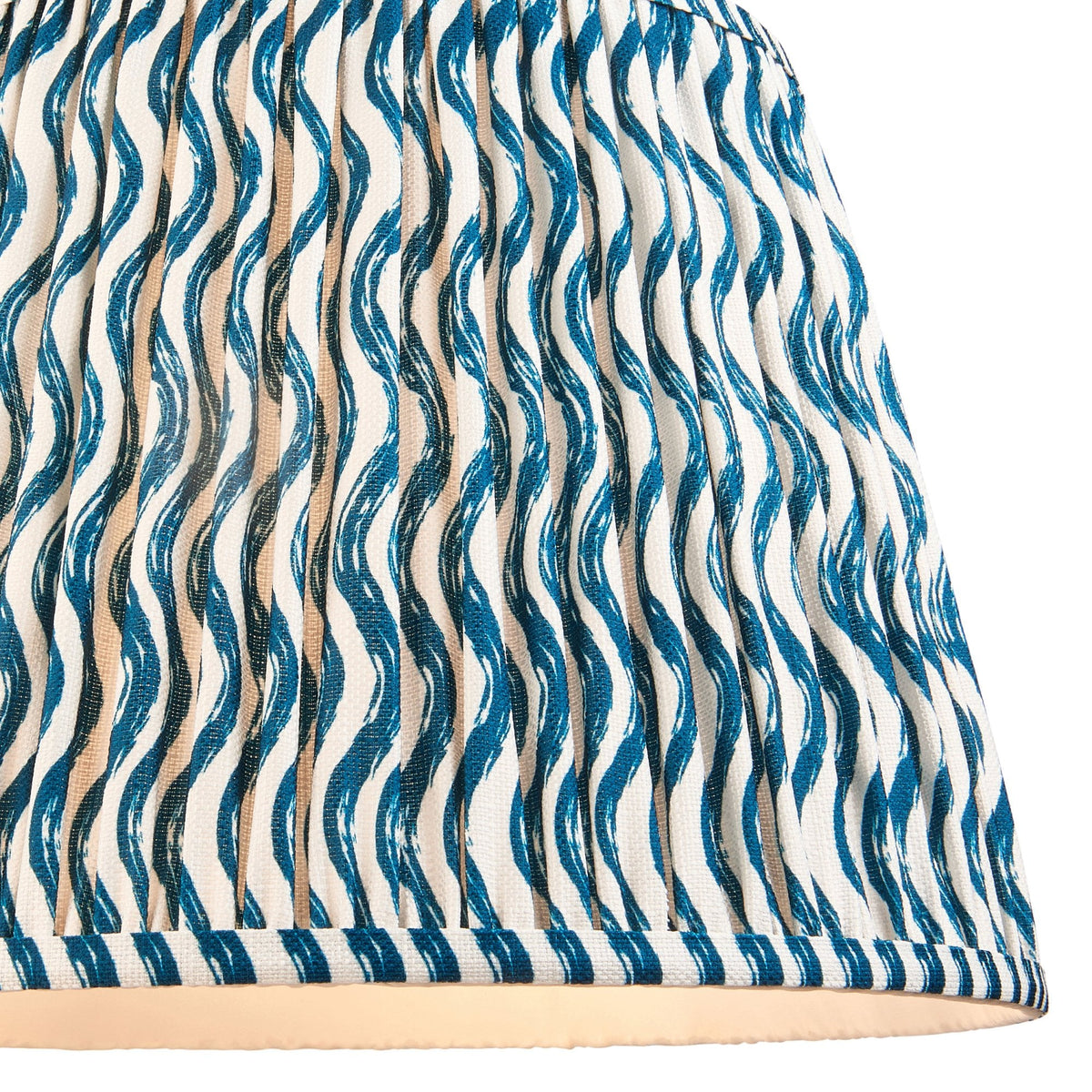 A close-up of the blue and white wavy patterned pleats of the lampshade.