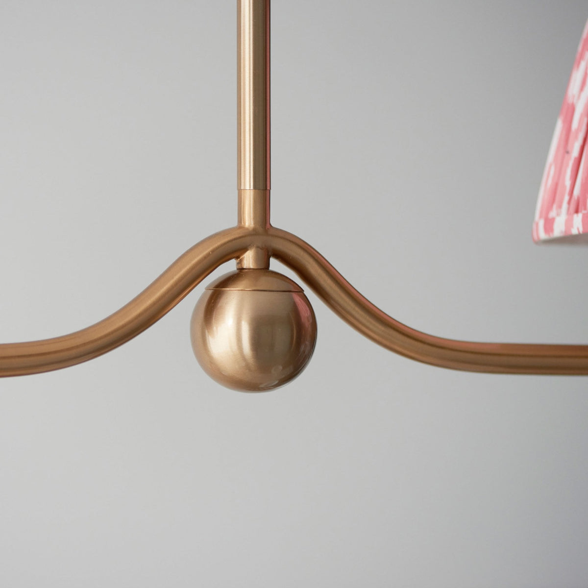 Close-up of the central decorative sphere on the gold pendant light fitting.