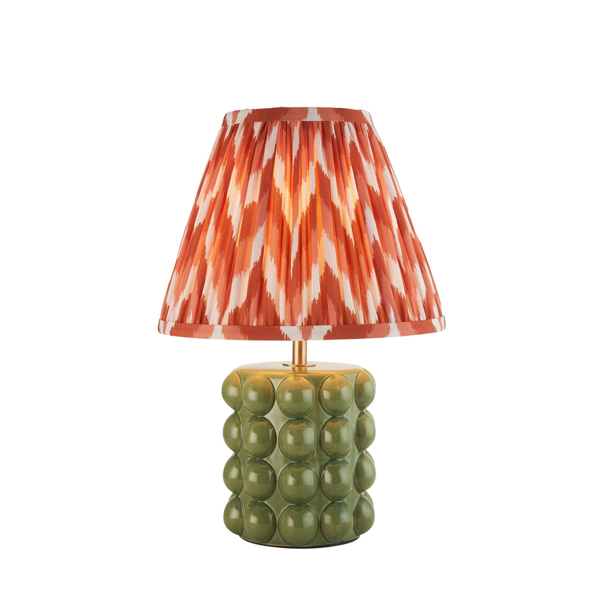 A small table lamp with an olive green ceramic base and a pleated orange and white shade.