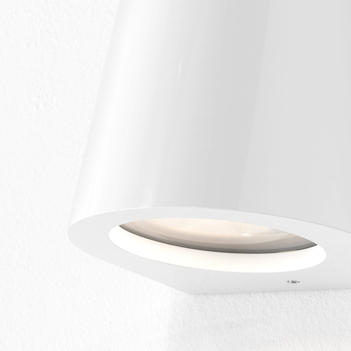 White wall light with a circular opening and a warm glow