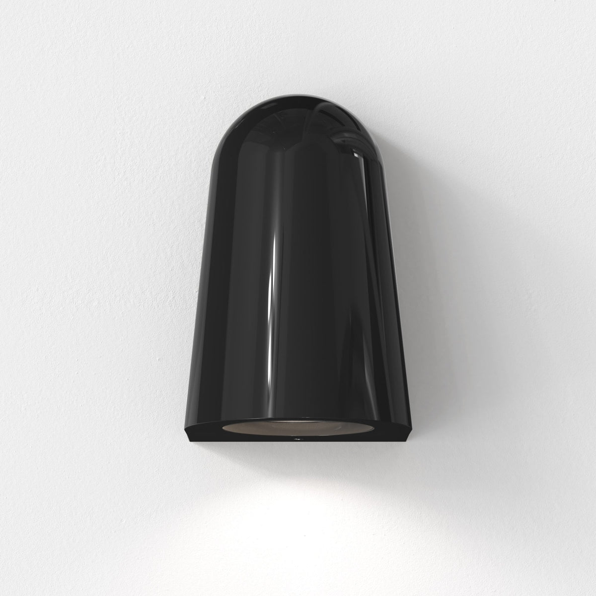 Black bell-shaped wall sconce with a shiny finish, casting light downwards on a white textured wall