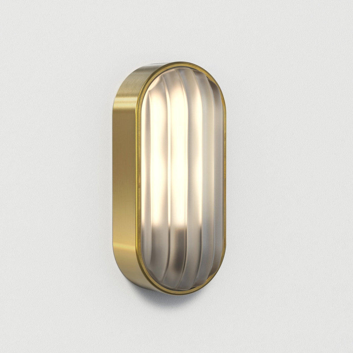 Oval brass wall light with a ribbed glass diffuser