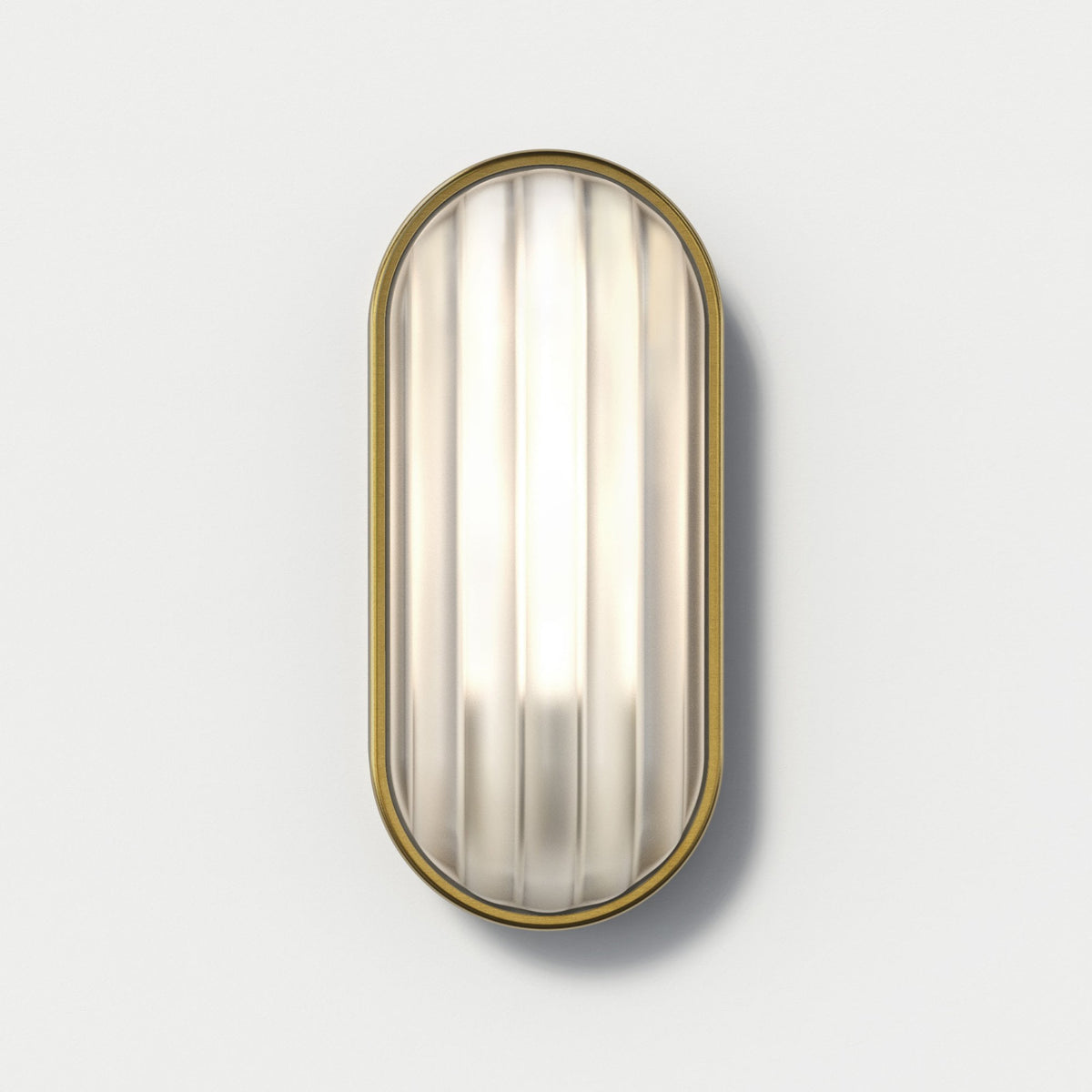 Oval wall light with a fluted glass diffuser and a brass frame