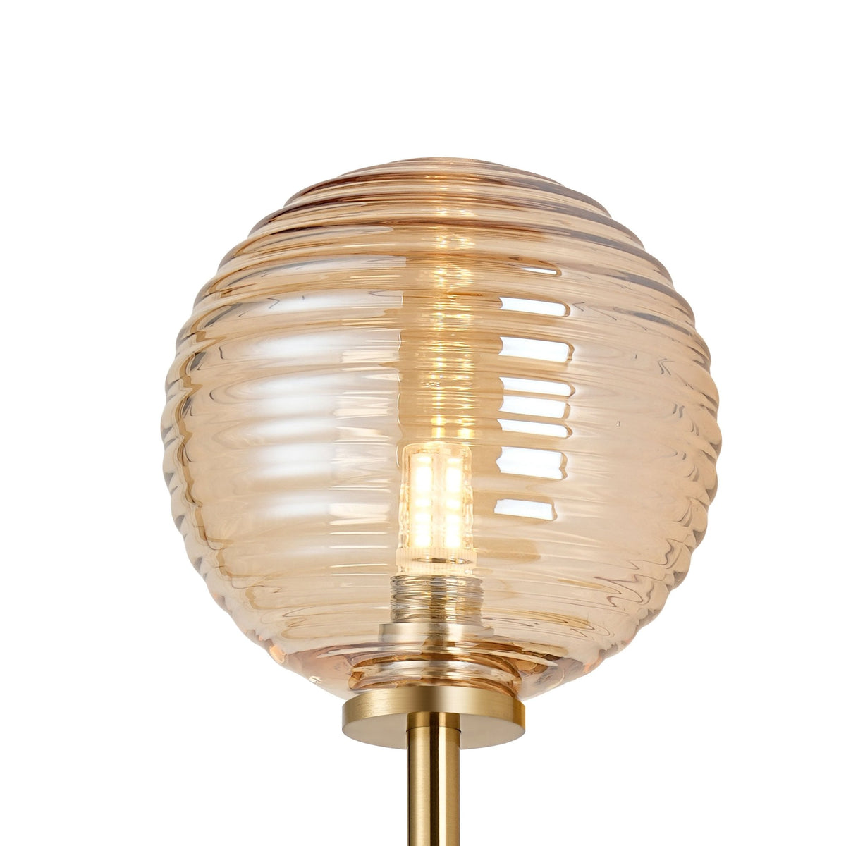 Close-up of a single amber ribbed glass globe shade from a wall light, glowing softly.