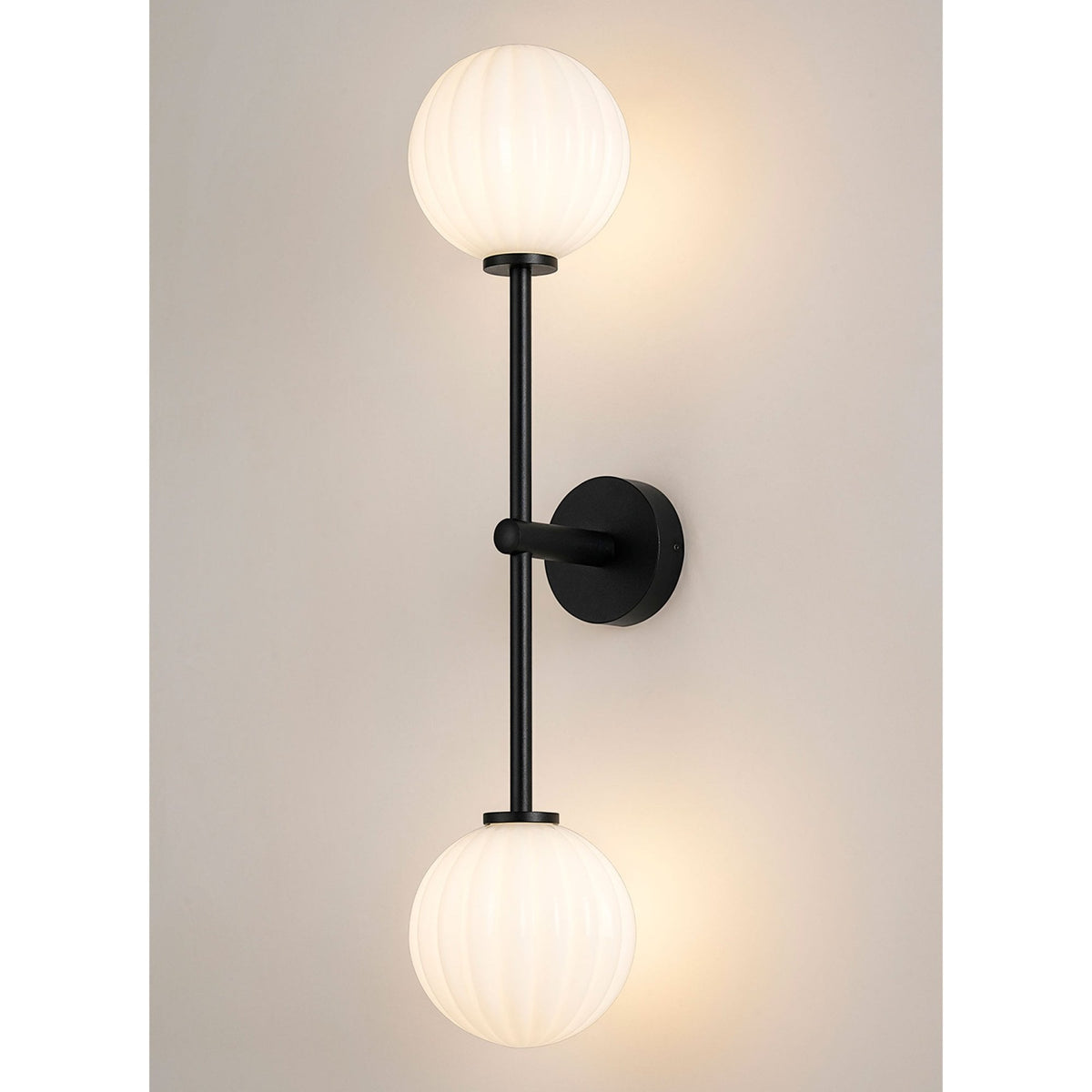 A modern black wall light with two ribbed white globe shades.