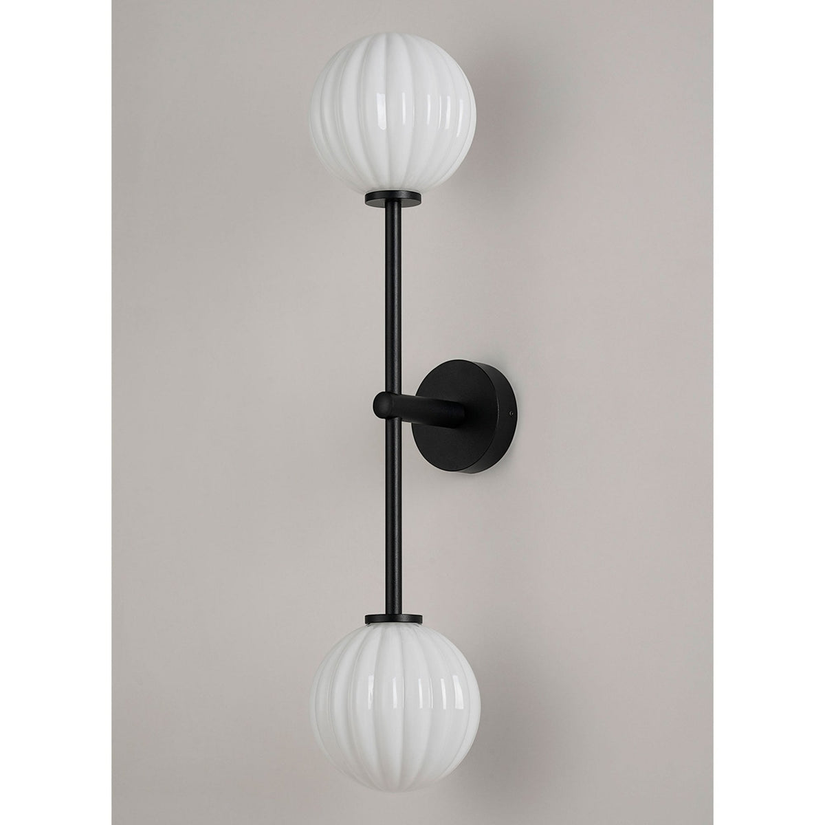 A contemporary black wall light featuring two ribbed white globe diffusers.