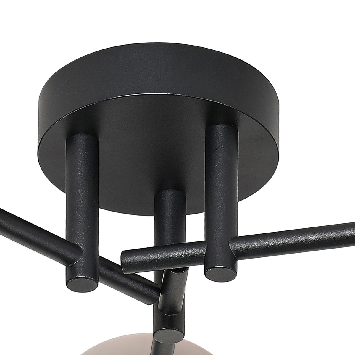 Close-up of the black circular ceiling rose and support arms of the light fitting.