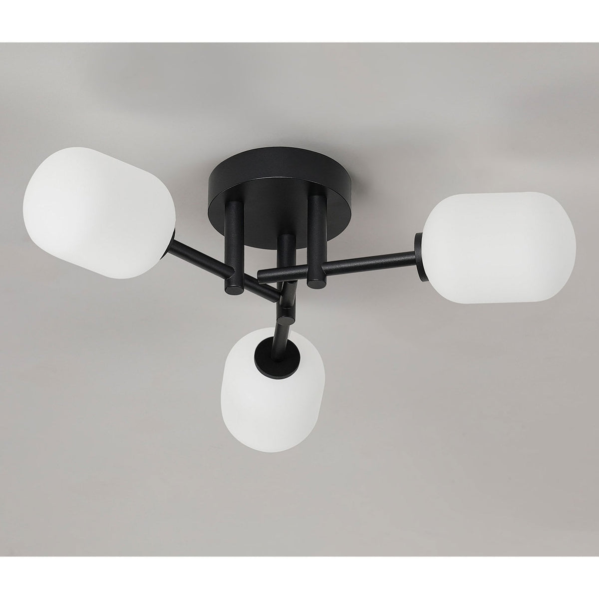 A contemporary black ceiling light with three white globes, casting light upwards.