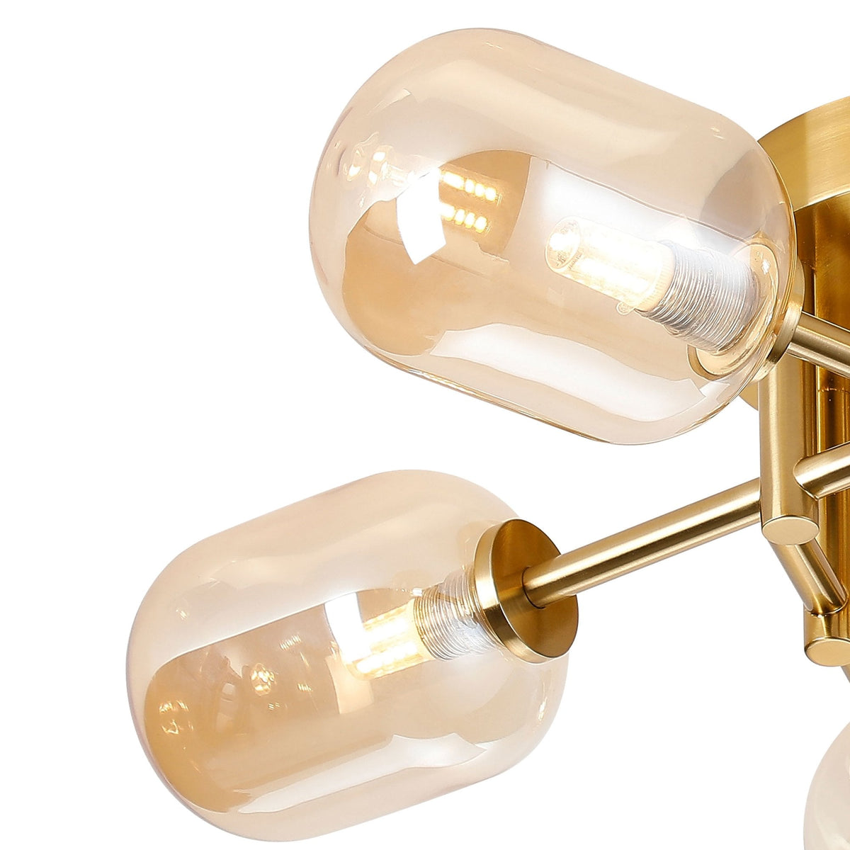 Close-up of two amber glass shades and the brass fixture of a ceiling light.