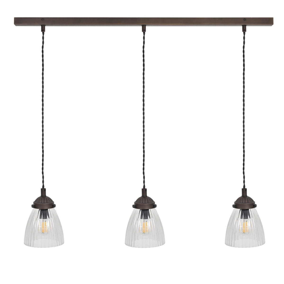 Three pendant lights with ribbed glass shades and Edison bulbs hang from a bronze bar.