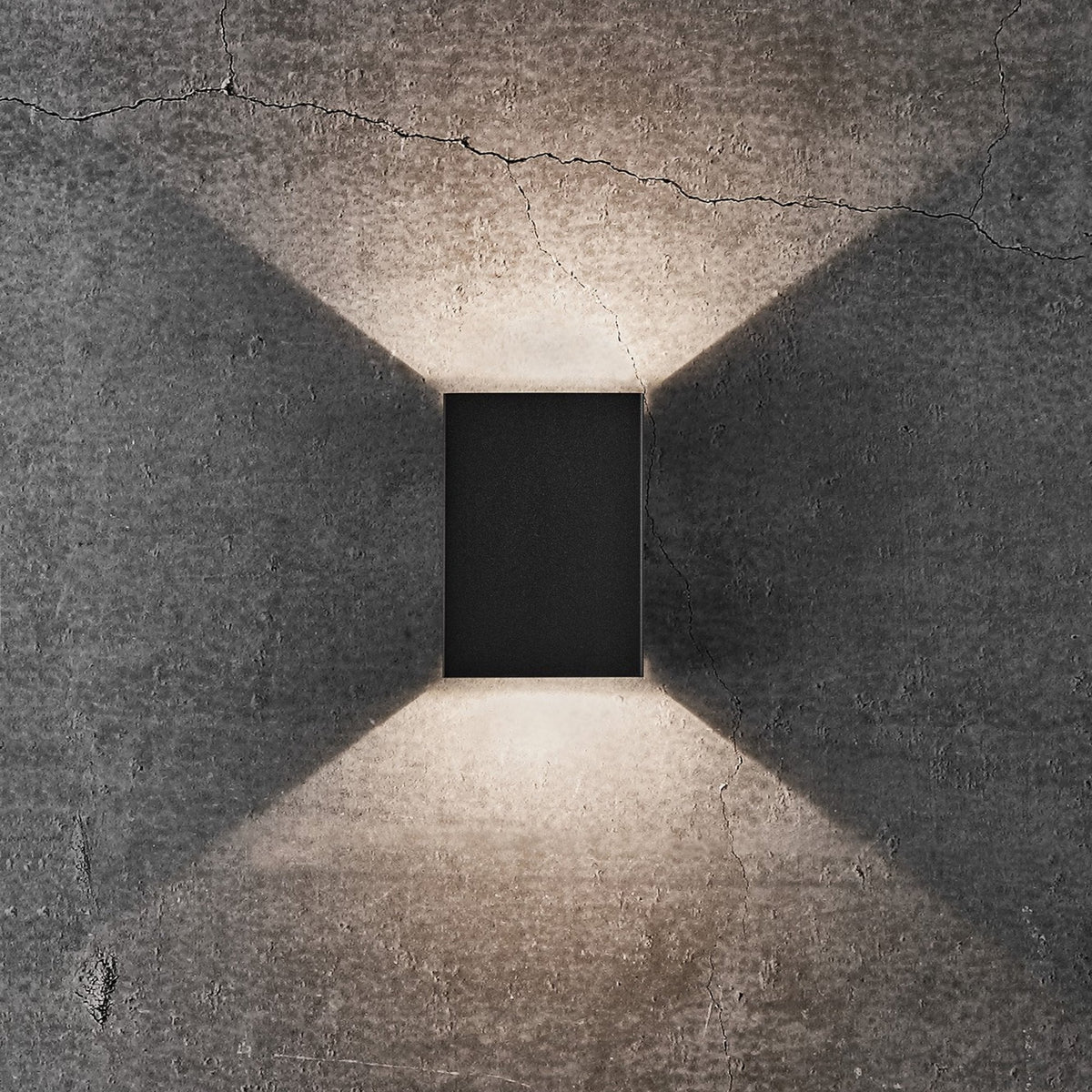 Black rectangular wall light with light shining upwards and downwards in a wide beam