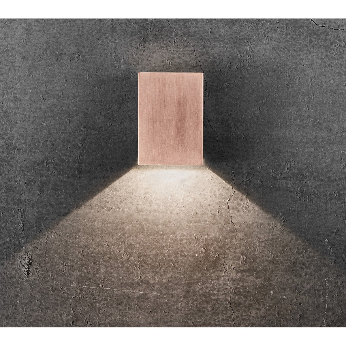 A copper outdoor wall light casts light downwards in a wide beam.