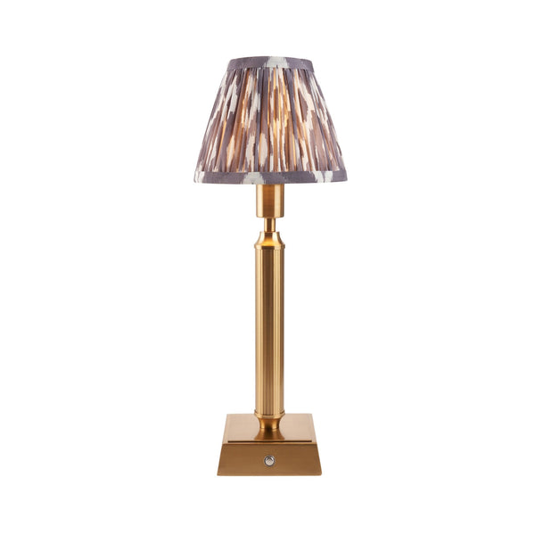 A rechargeable table lamp with a patterned ikat shade on a white background.