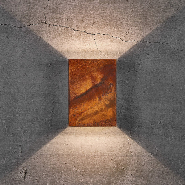 An upward and downward glowing outdoor wall light in a rustic rusted finish.