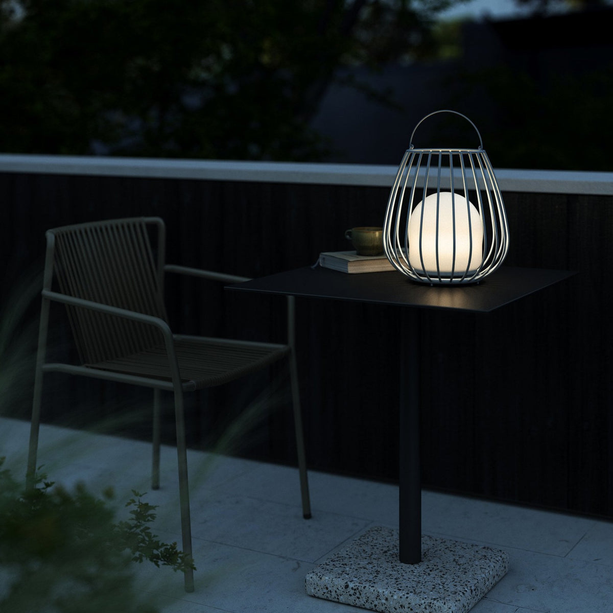 A close up of the lamp at night on a balcony setting.
