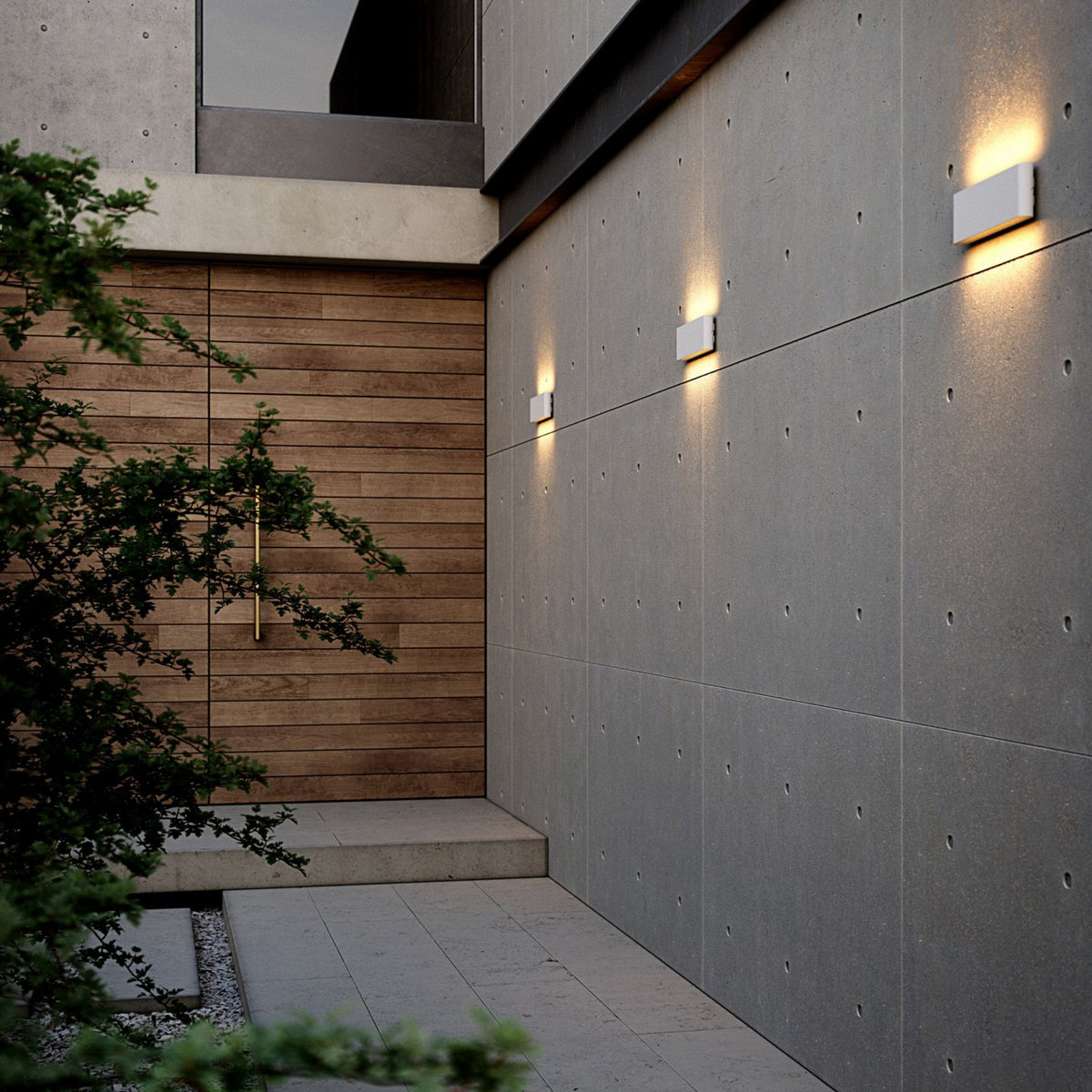 Three white outdoor wall lights illuminate a modern grey building exterior.