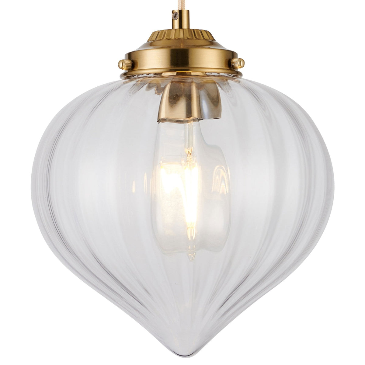 A close up of the pendant light, showcasing the ribbed glass and brass cap.