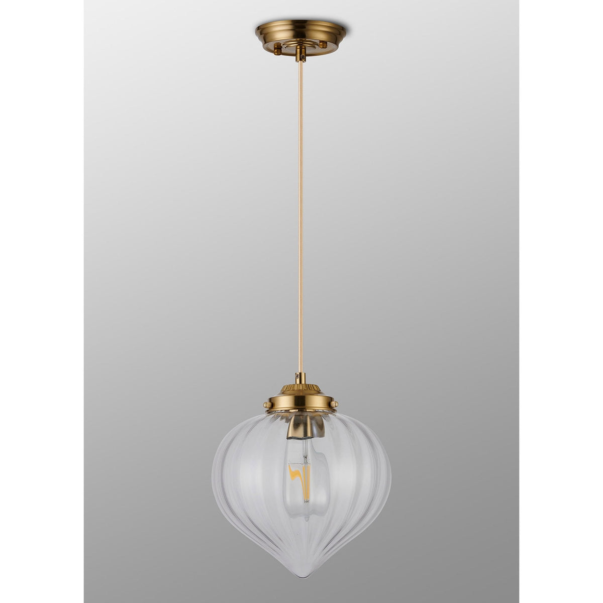 The pendant light with the light off, displaying the ribbed glass and brass details.