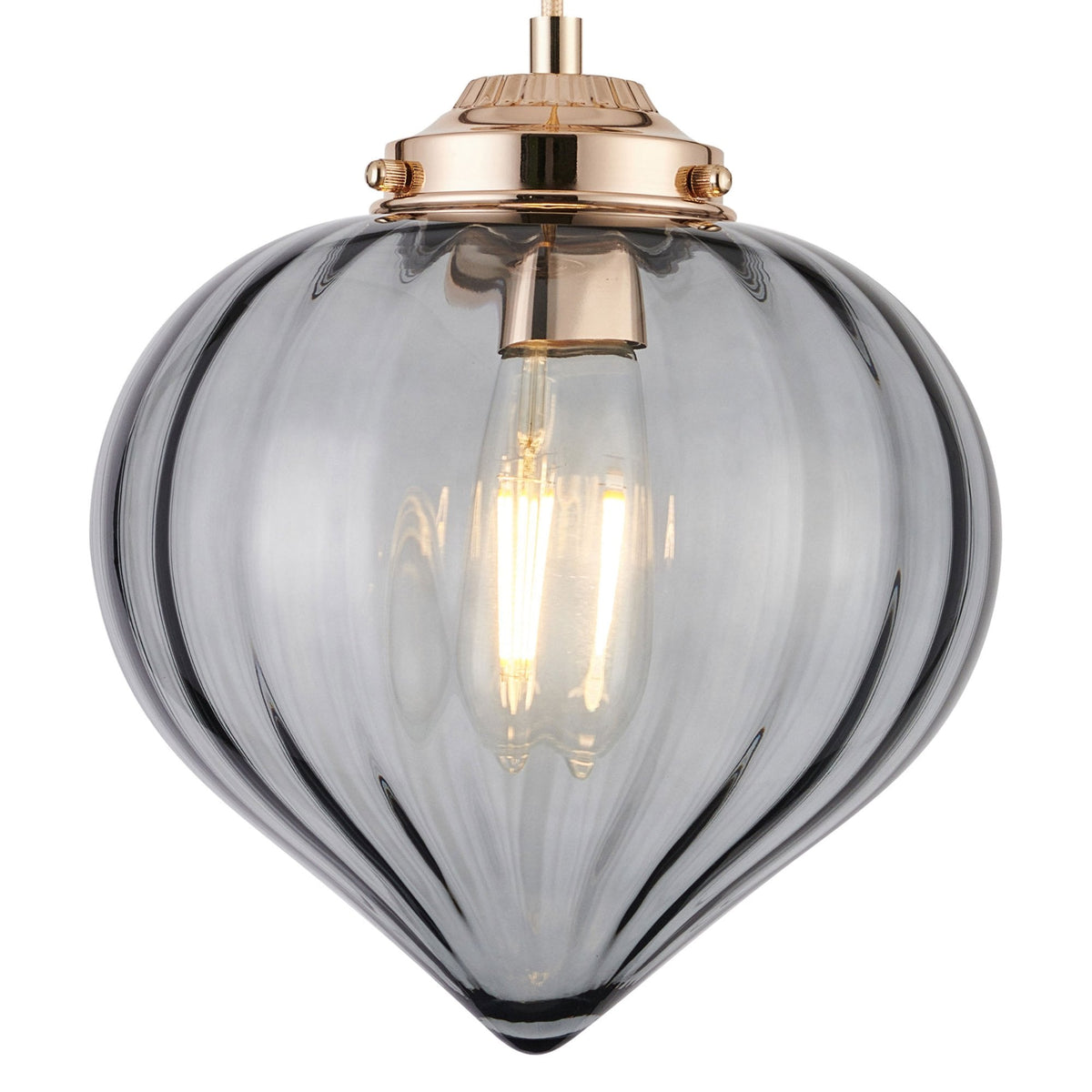 An oblong, vertically ridged, grey glass lampshade with a gold-coloured top.