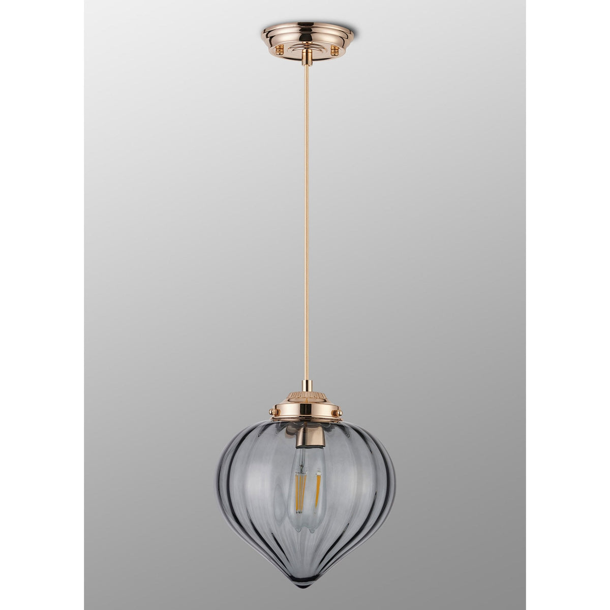 A full-length view of an oblong, vertically ridged, grey glass lampshade with a gold-coloured top.