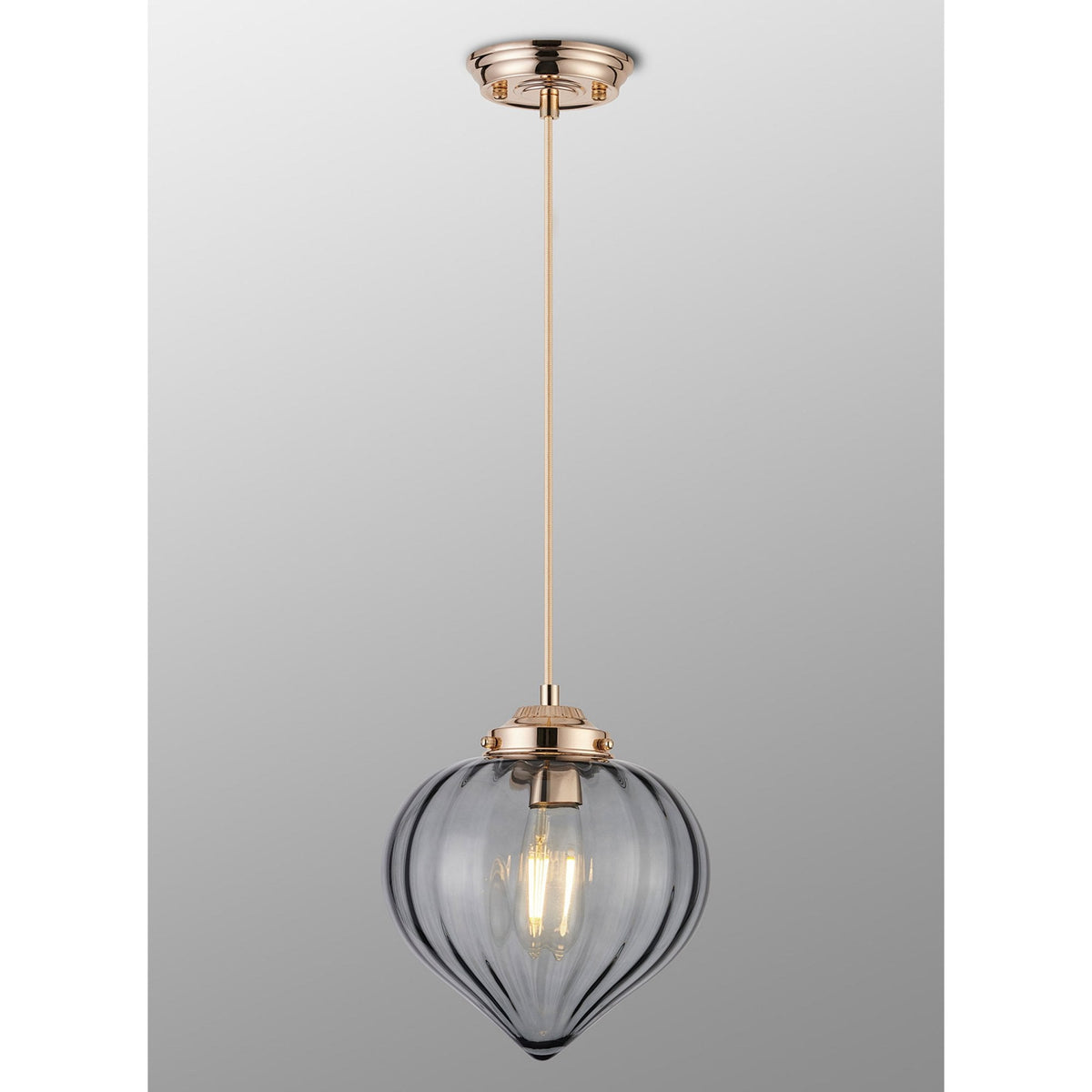 A front view of an oblong, vertically ridged, grey glass lampshade with a gold-coloured top.