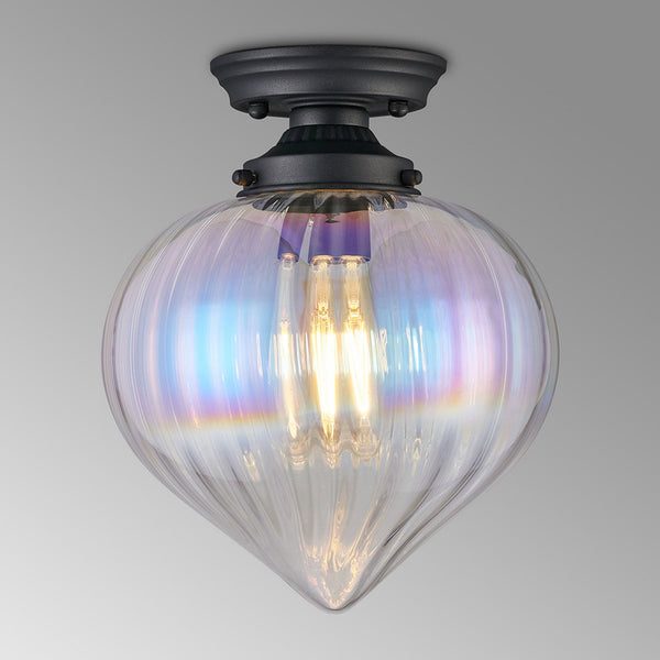 A close-up of a ceiling light featuring a clear, iridescent glass shade and a dark base.
