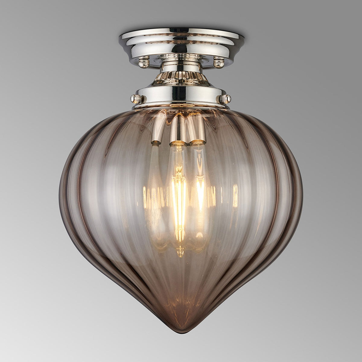 A close-up of a ceiling light featuring a polished nickel base and a smoked fluted glass shade.