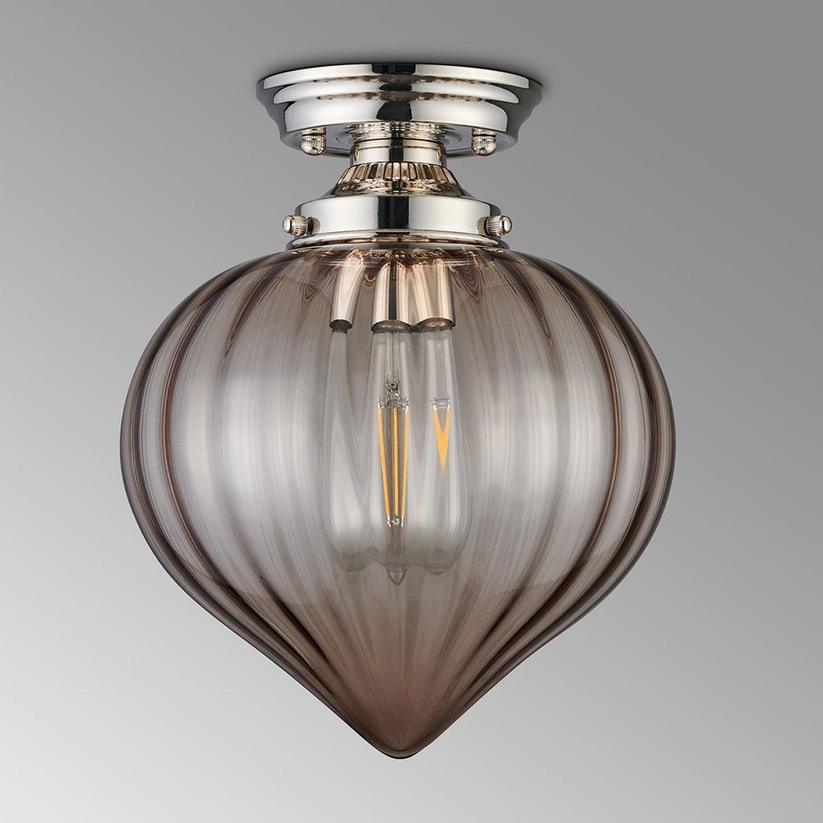 A modern ceiling light with a polished nickel base and a smoked fluted glass shade on a grey background.
