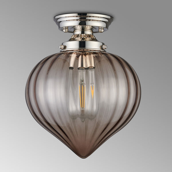 A modern ceiling light with a polished nickel base and a smoked fluted glass shade on a grey background.