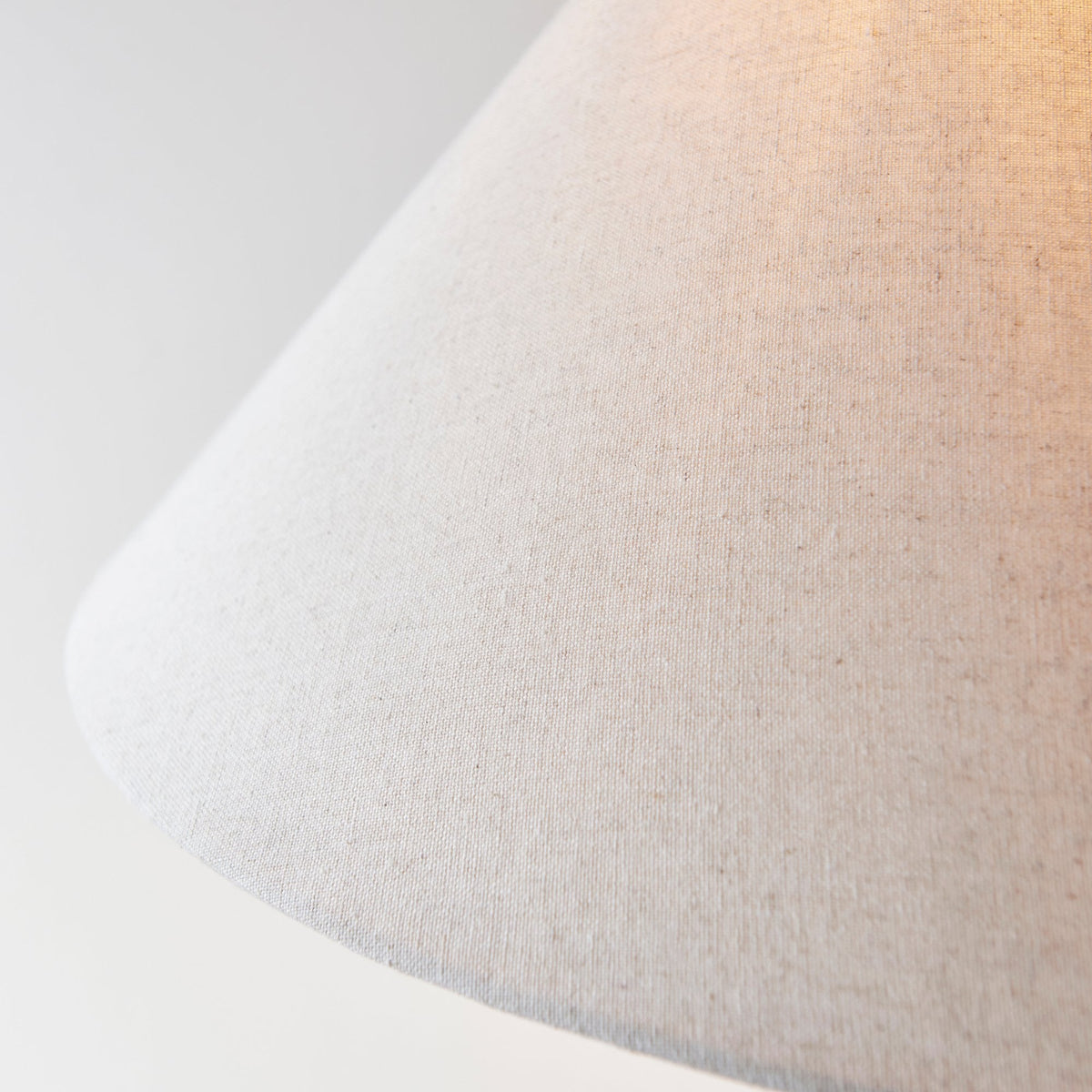 Close-up of the textured fabric of a cream-colored lamp shade.