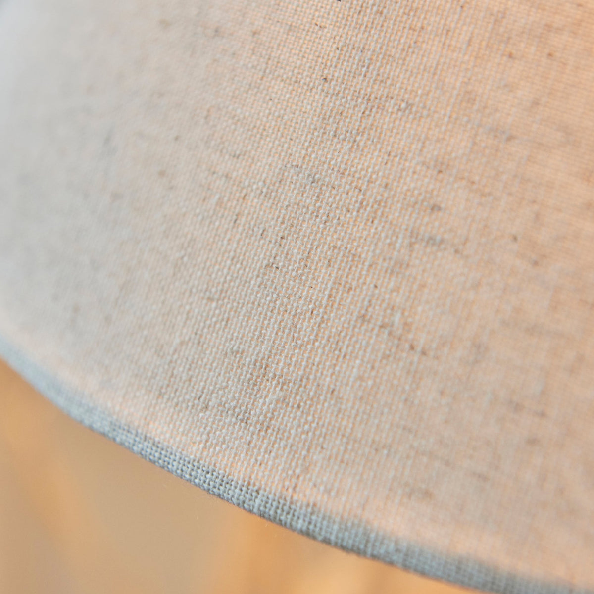 A close-up shot of the grey fabric of the antique table lamp's lampshade.