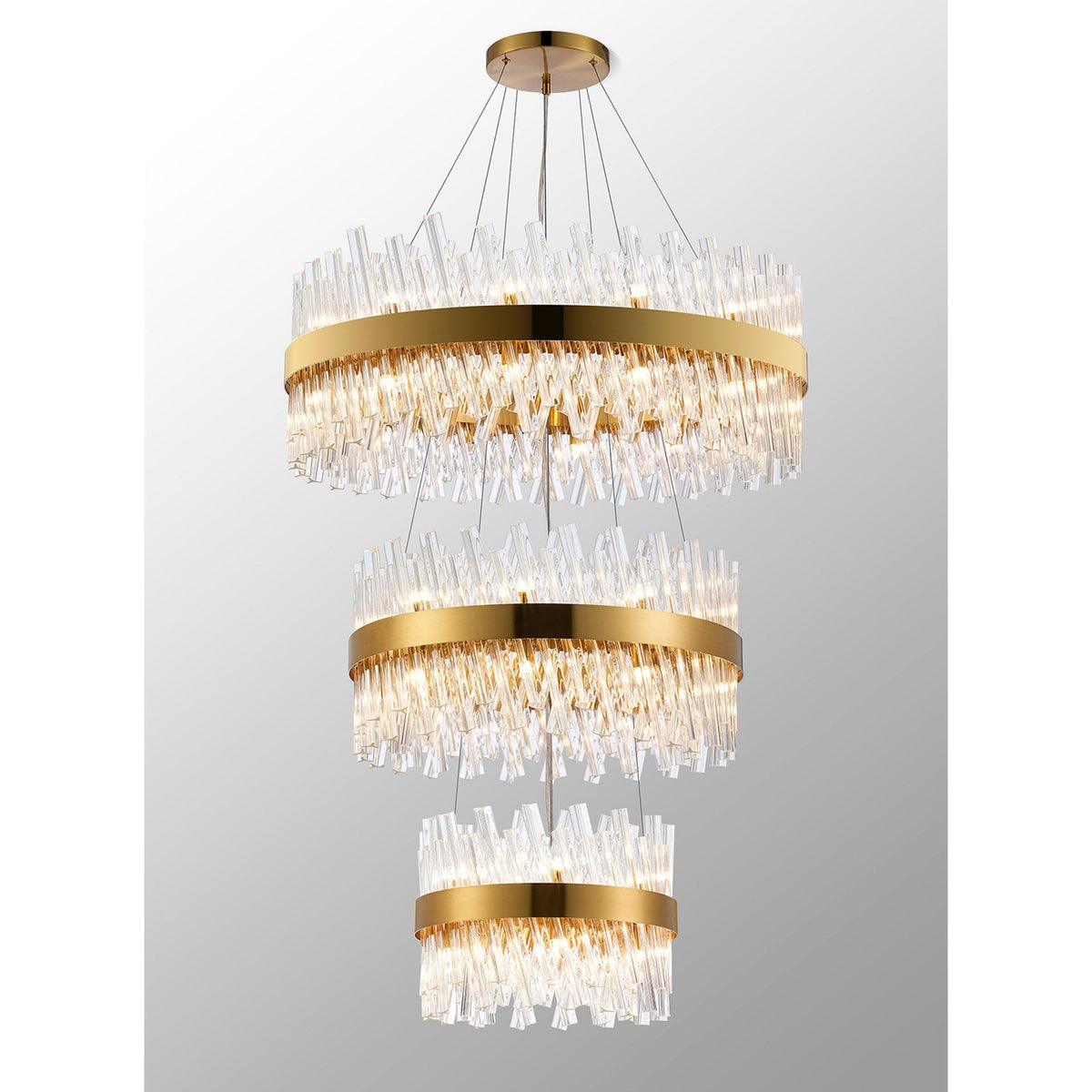 A multi-tiered gold and clear glass chandelier, showcasing individual glass rods creating texture.