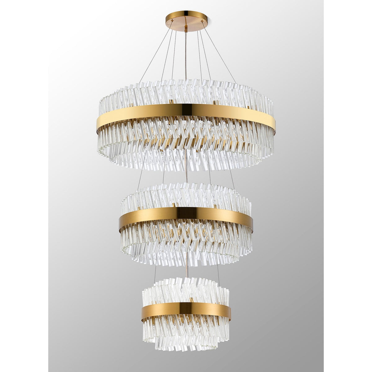 A grand, three-tiered chandelier in gold and clear glass, with a sparkling, textured design.