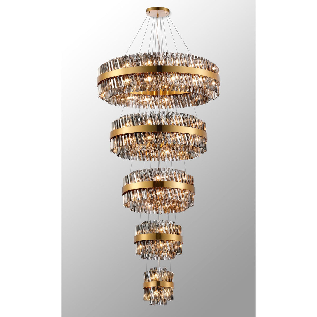 A luxurious tiered chandelier with golden bands and sparkling crystal rods, illuminated brightly.