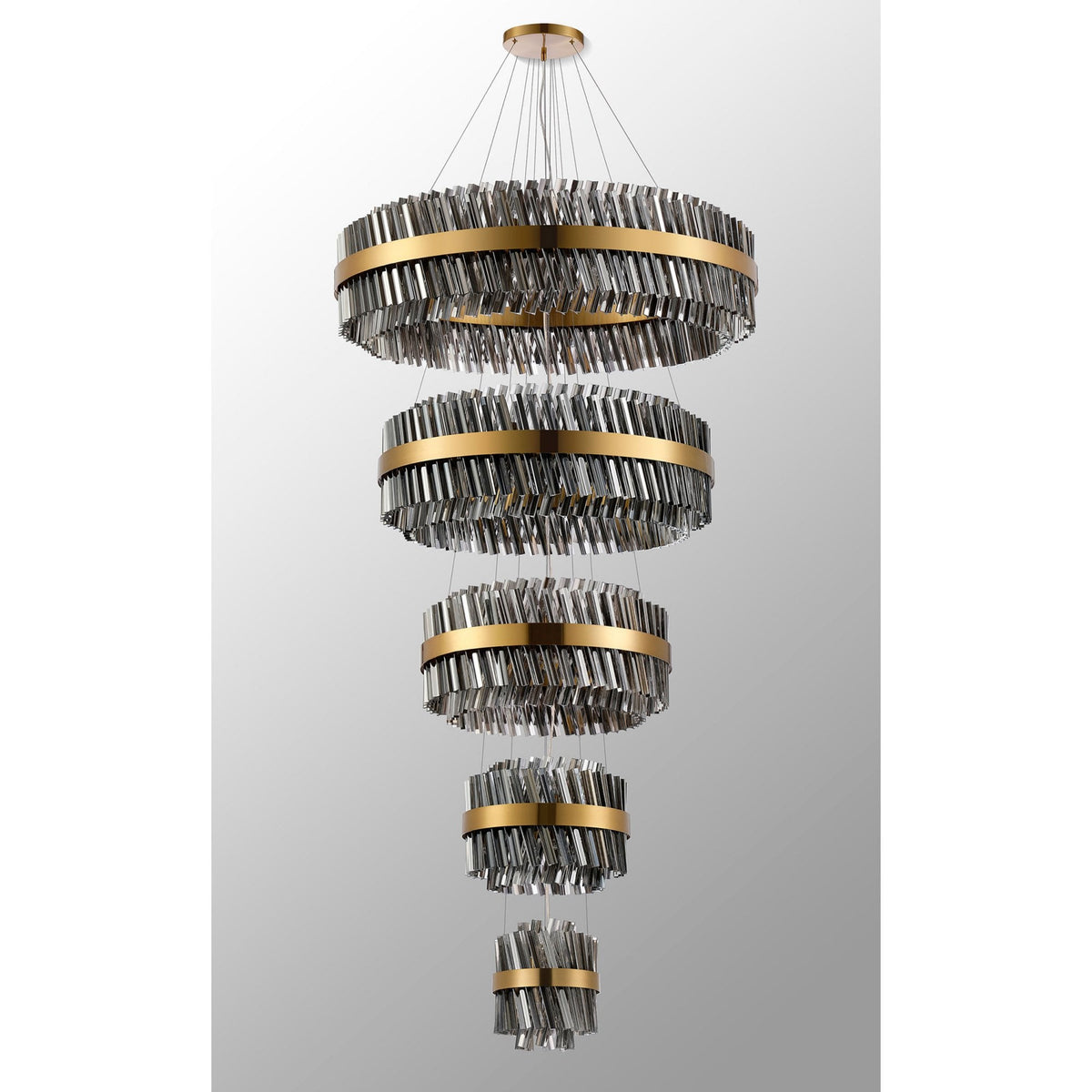 A luxurious tiered chandelier with golden bands and sparkling crystal rods, unlit.