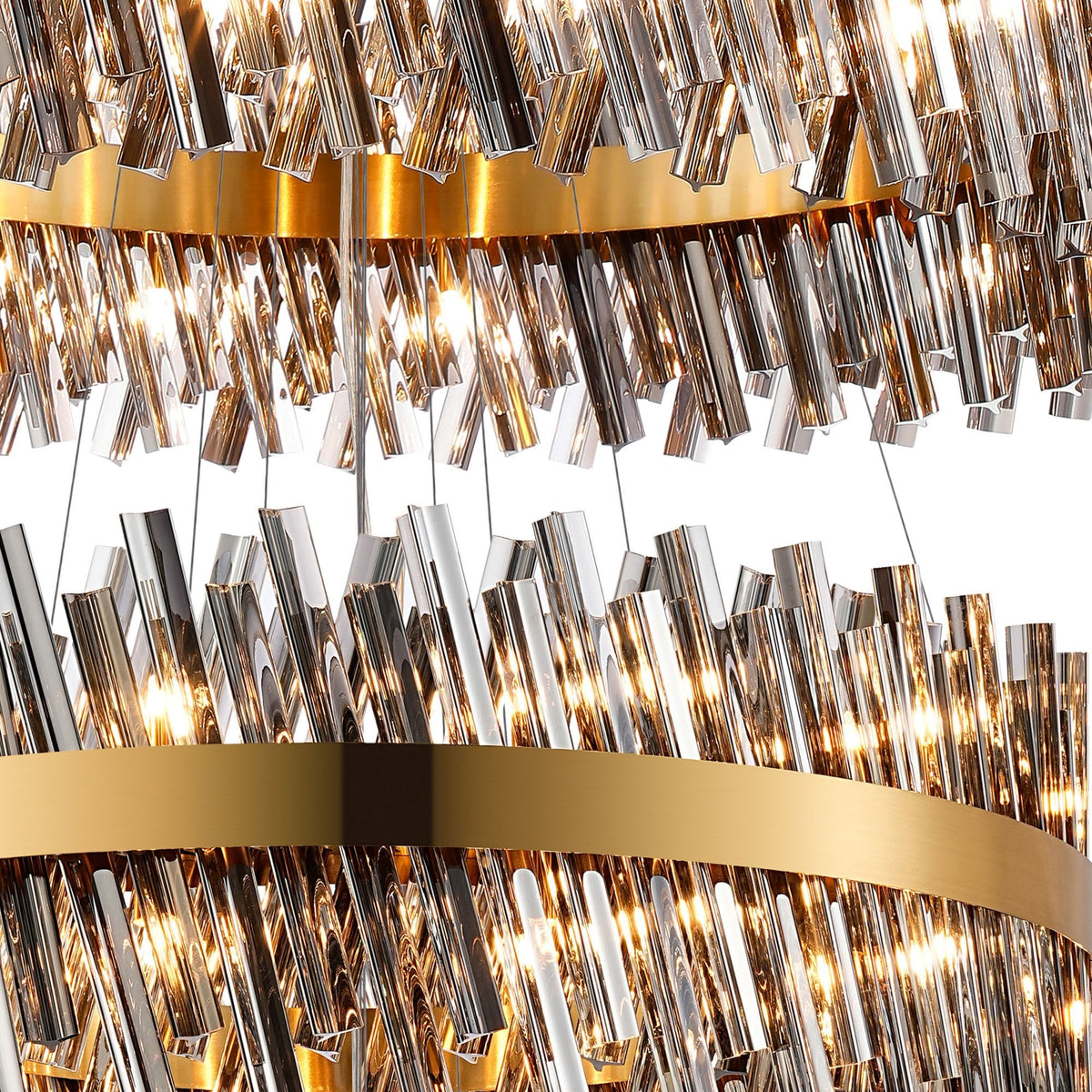 A close-up of a tiered chandelier with golden bands and sparkling crystal rods, illuminated.