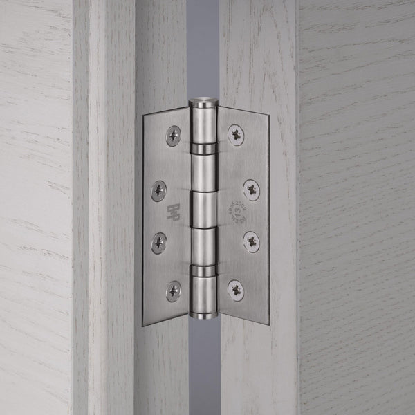 Satin chrome door hinge installed on a light wood door frame.