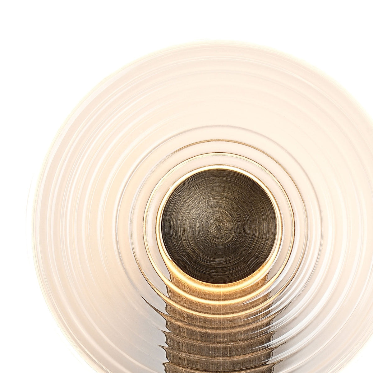 Close-up of a modern wall lamp's round, clear, ribbed glass shade and dark metal centre.