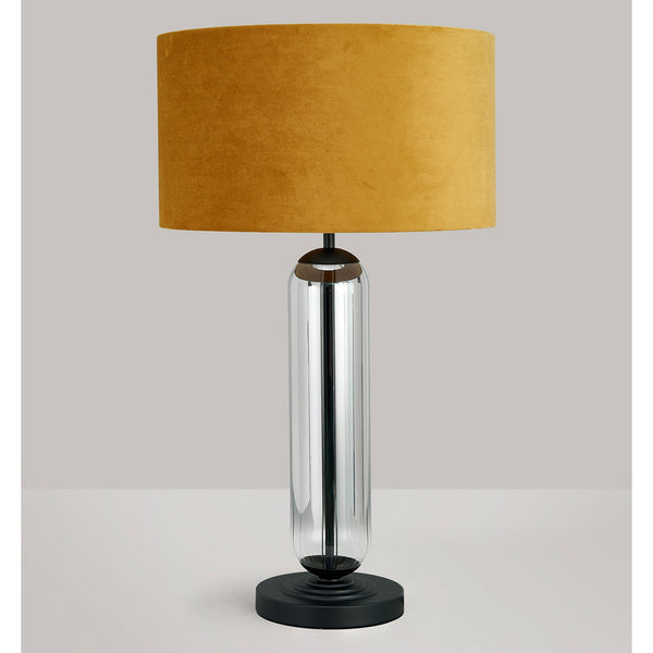 A modern chrome table lamp with a dark yellow velvet shade on a light background.