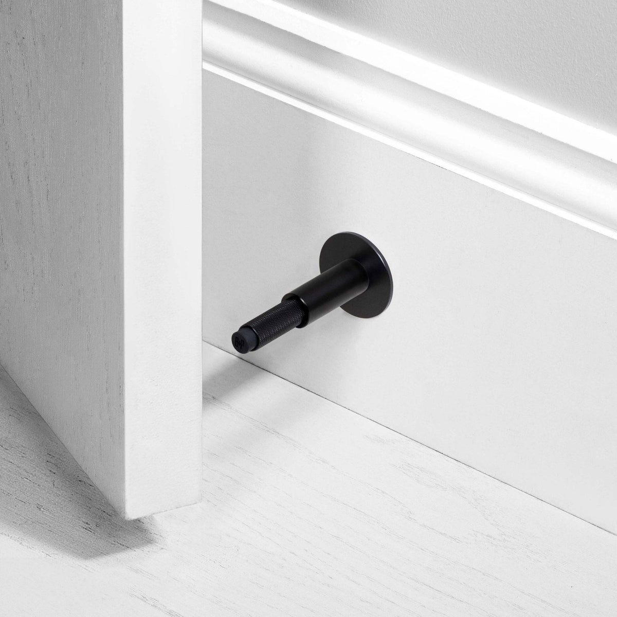 Cross Cut Knurled Wall Mounted Door Stop in Black